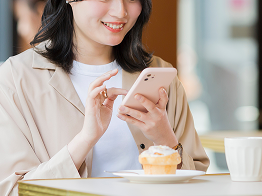 女性客がスマートフォンを利用している写真