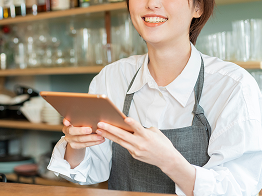 店員がタブレット端末を笑顔で操作している写真